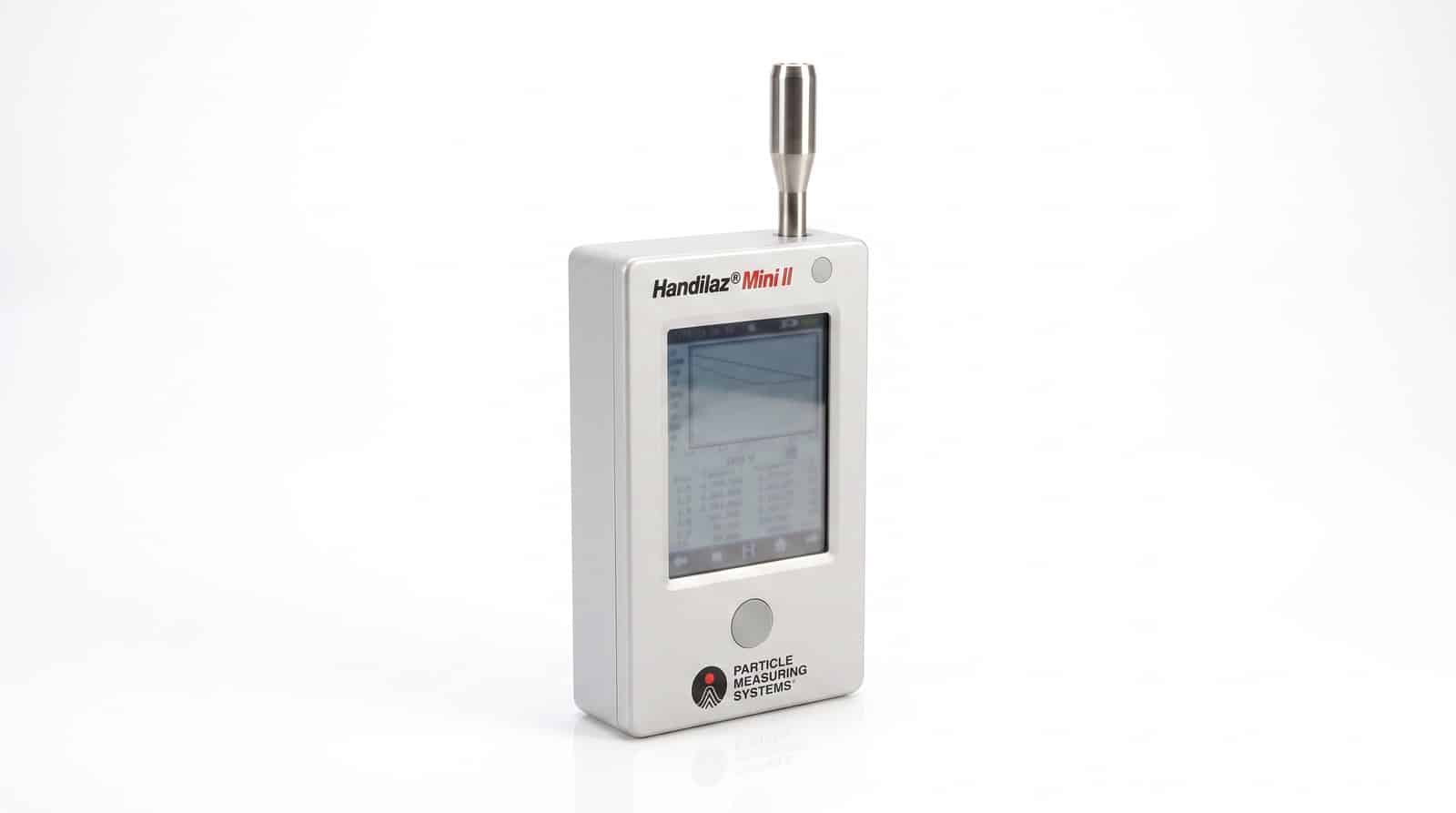 Máy đếm hạt cầm tay PMS Handilaz Mini II nhìn ba phần tư trên nền trắng — thân bạc, đầu lấy mẫu đẳng động học và màn hình cảm ứng màu