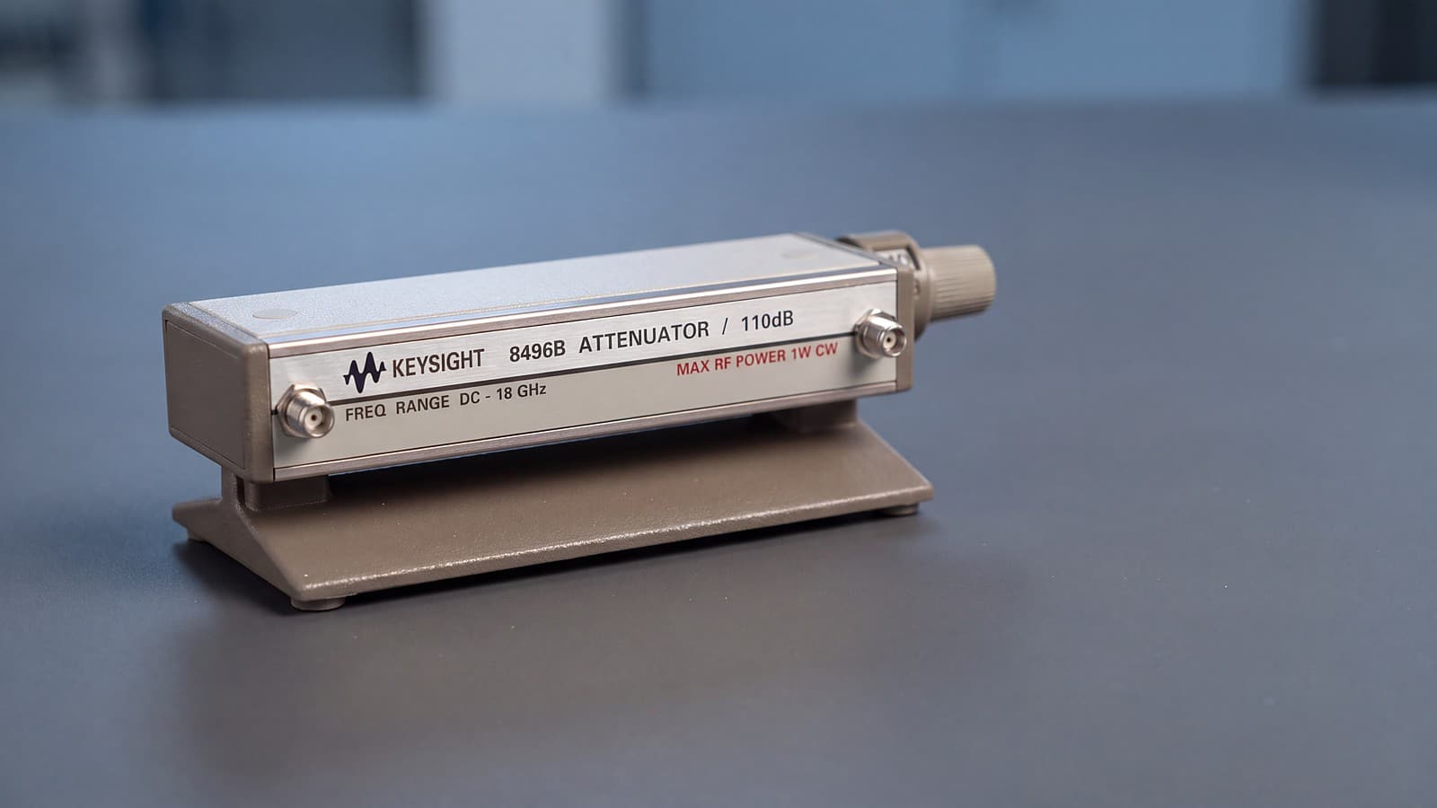 Bộ suy hao bước Keysight 8496B đặt trên bàn đo phòng thí nghiệm RF, nhãn mặt máy ghi giới hạn công suất vào 1 W liên tục