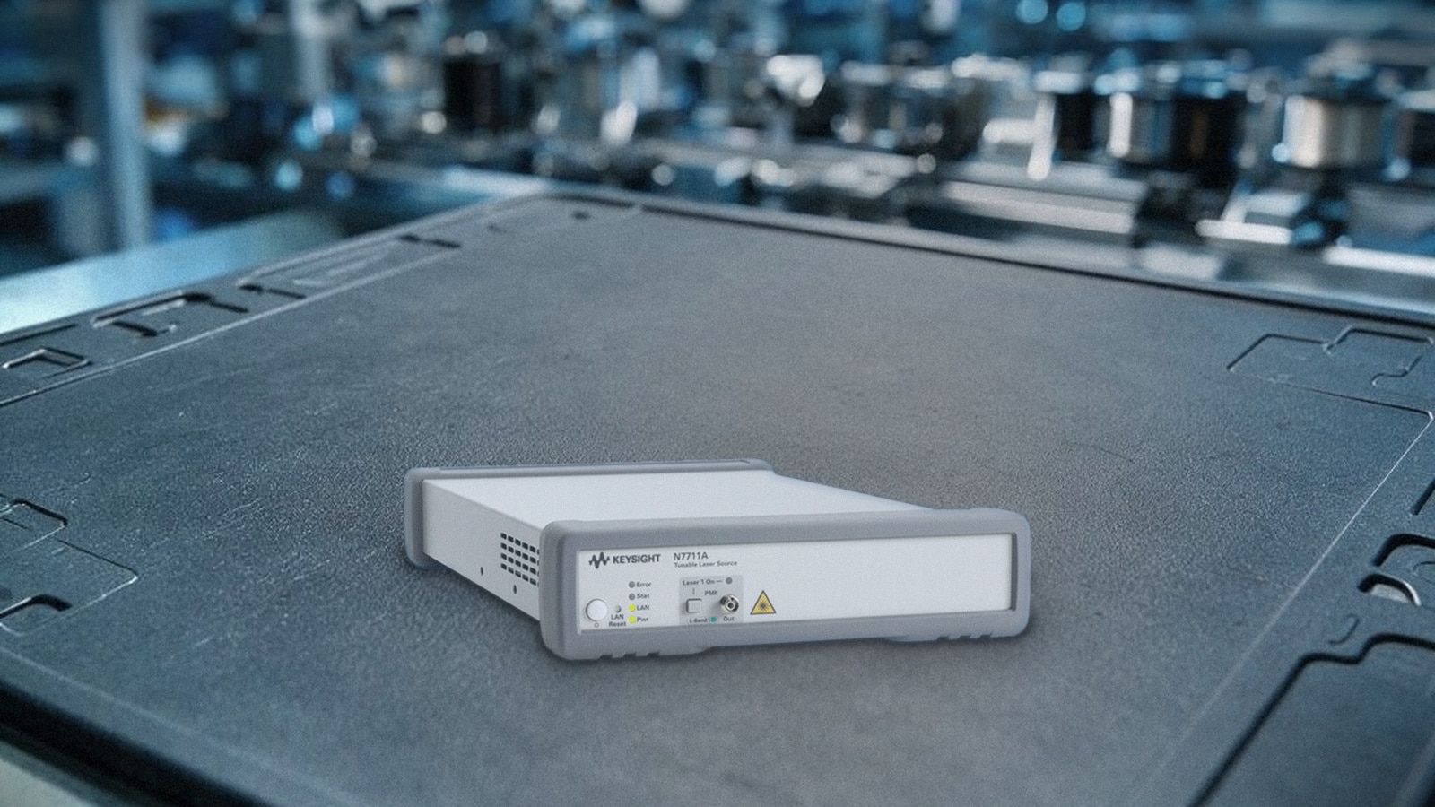 Nguồn laser điều chỉnh Keysight N7711A trên thảm ESD tại xưởng sản xuất linh kiện quang