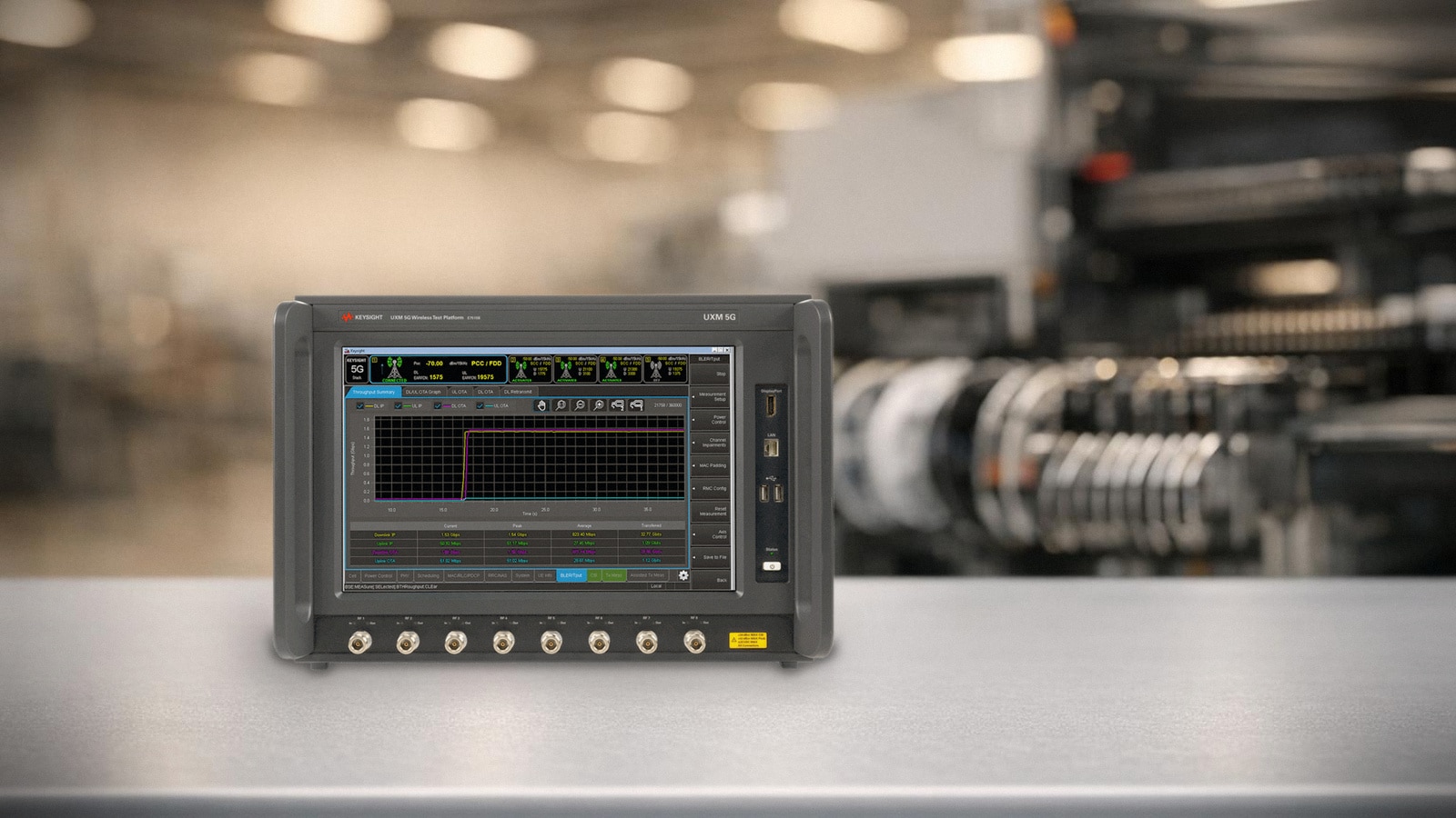 Trạm đo kiểm thiết bị 5G với nền tảng Keysight E7515B đặt cạnh dây chuyền trong nhà máy