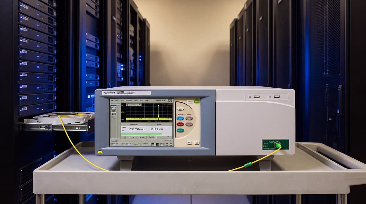 Đo bước sóng kênh DWDM bằng Keysight 86122C trong phòng máy viễn thông, dây nhảy quang nối từ khay quản lý sợi