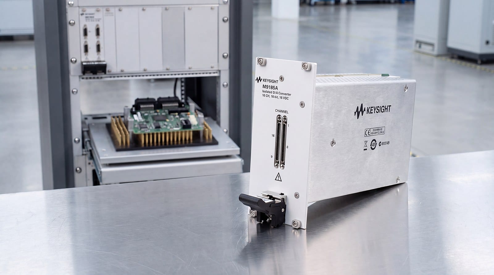 Keysight M9185A tại trạm kiểm tra chức năng bo mạch điều khiển ô tô, phía sau là tủ rack và đồ gá kim